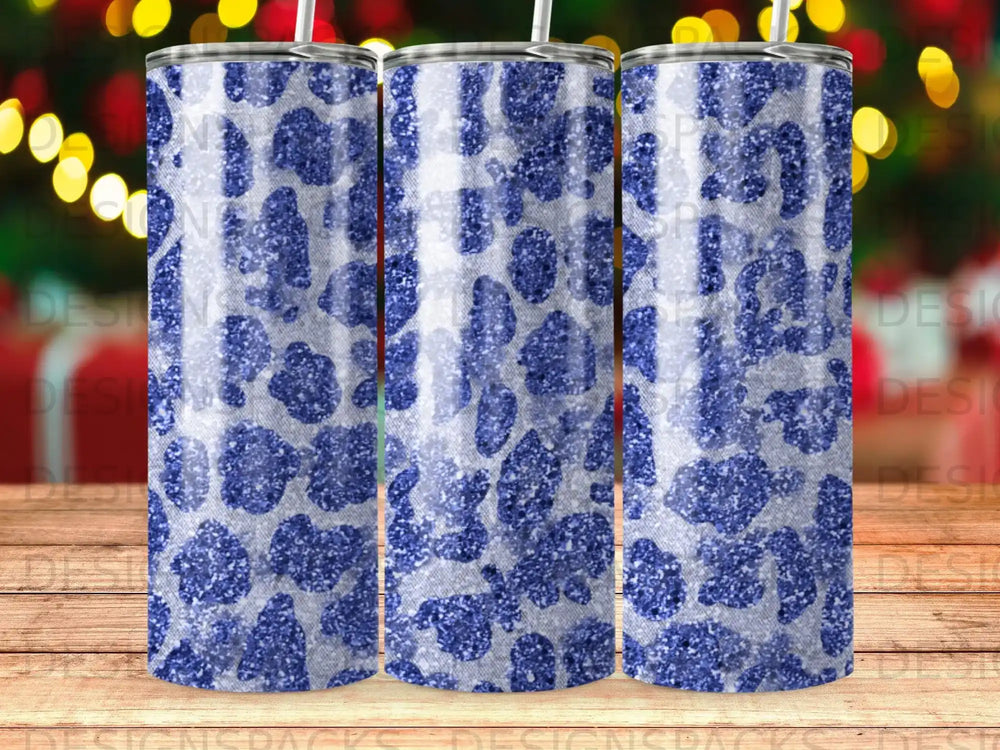 Blue leopard print tumbler with glitter accents, on a wooden surface.