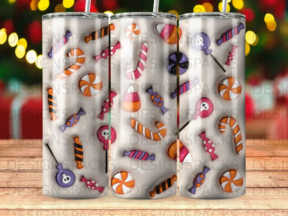Three tumblers with a colorful candy pattern of lollipops, candy corn, and swirl candies.