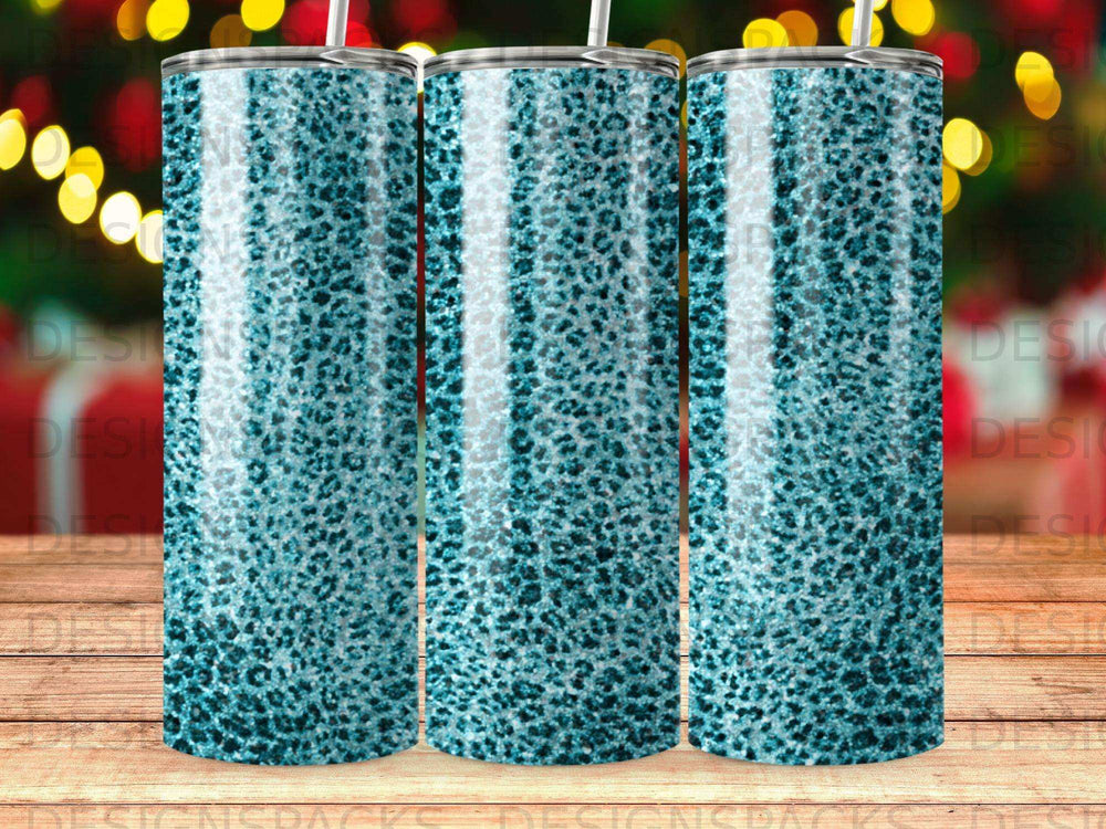Three teal leopard print tumblers with straws, blurred festive lights background.