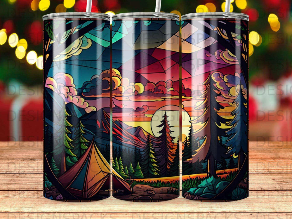 Tent at sunset with vibrant sky, trees, and mountains.