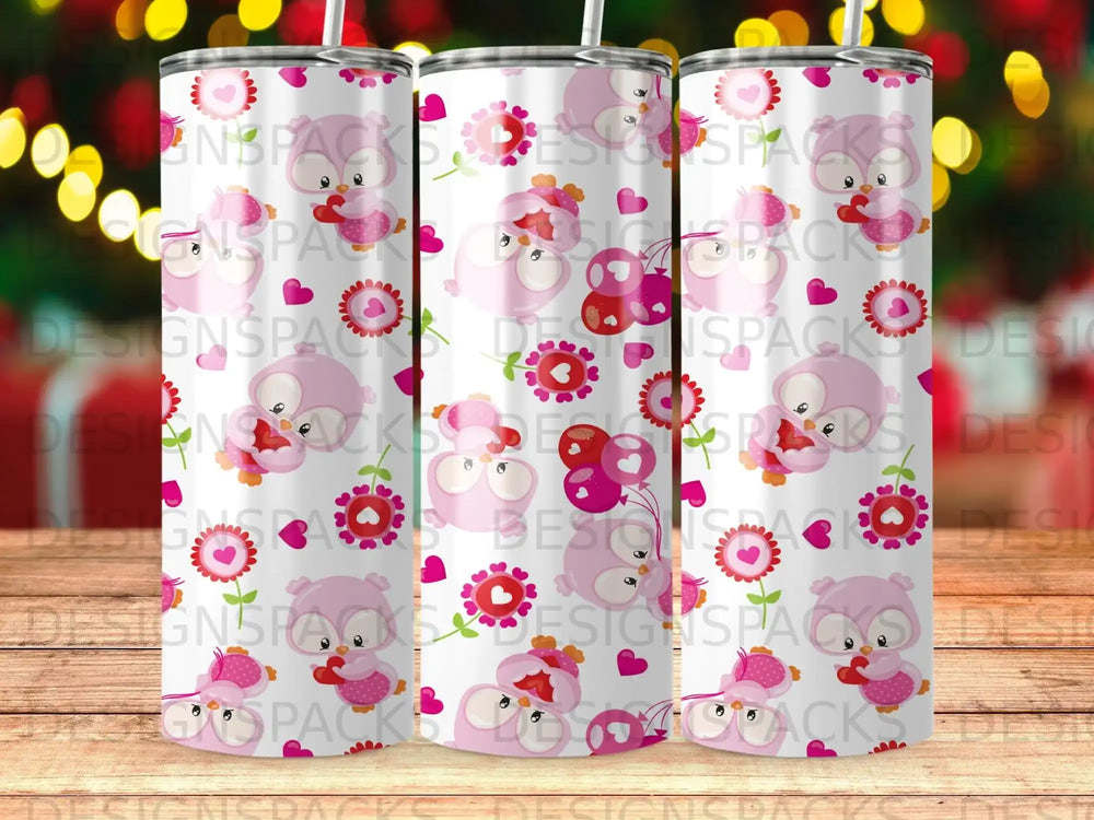 Three pink owl tumblers with hearts and flowers against a blurred festive background.