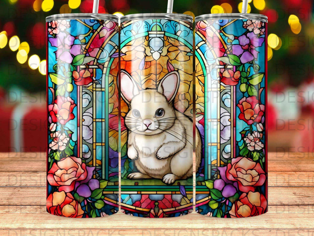 Stained glass bunny surrounded by floral motifs on a patterned tumbler.