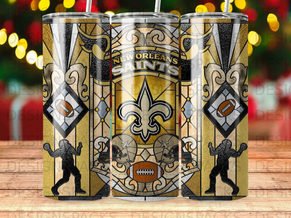 New Orleans Saints tumbler with gold fleur-de-lis, helmets, and football player motifs.