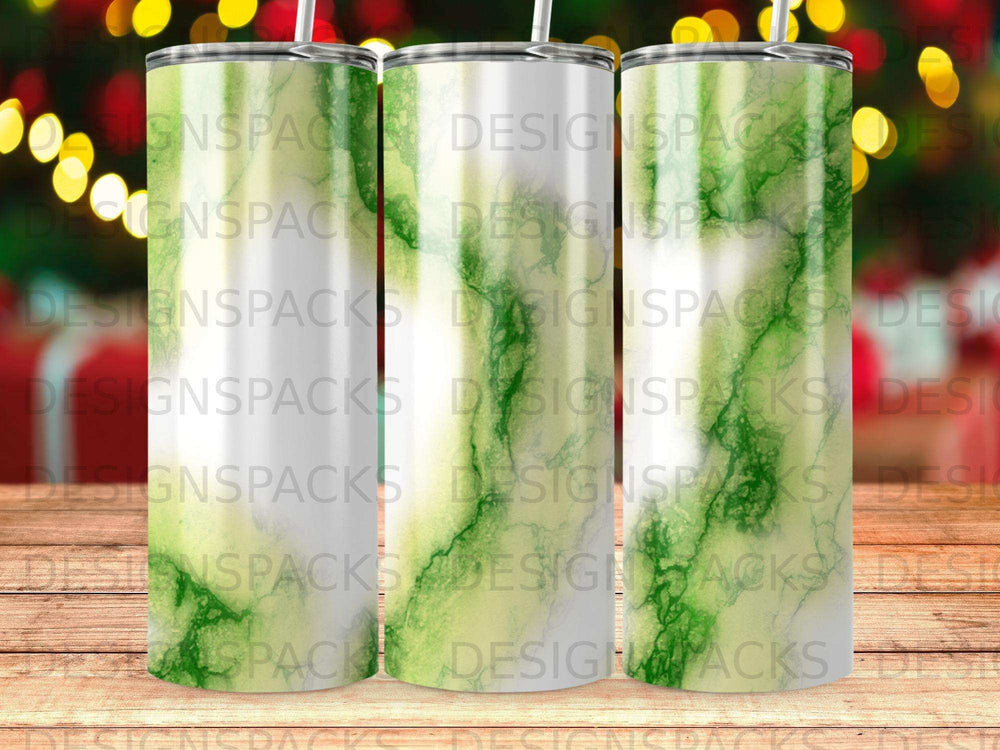 Three green marble-patterned tumblers on a wooden surface, blurred lights in background.
