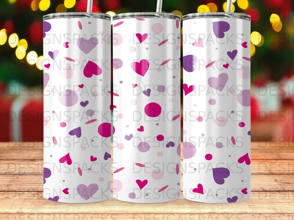 Three tumblers with a purple and pink heart pattern and "DESIGNSPACKS" watermark.