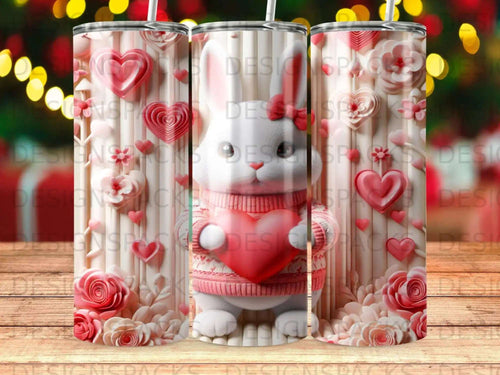 Bunny holding a heart with floral and heart pattern on tumbler.
