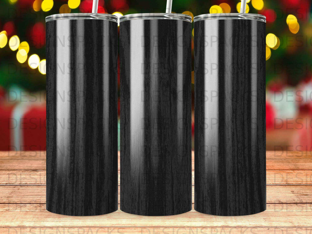 Three black wood grain tumblers with straws against a bokeh background.