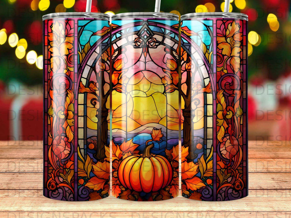 Stained glass tumbler design featuring a pumpkin and autumn leaves with sunset sky.