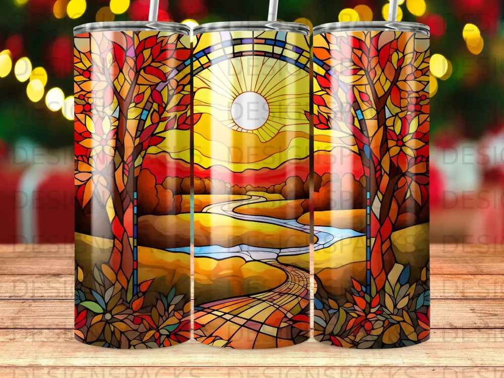 Stained glass design with autumn trees, river, and sun on a tumbler.