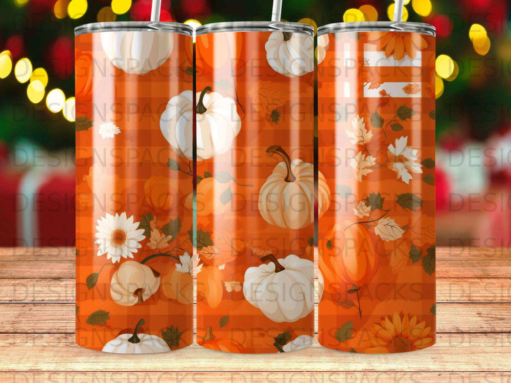 Orange pumpkin and fall leaf pattern on three tall tumblers with straw lids.