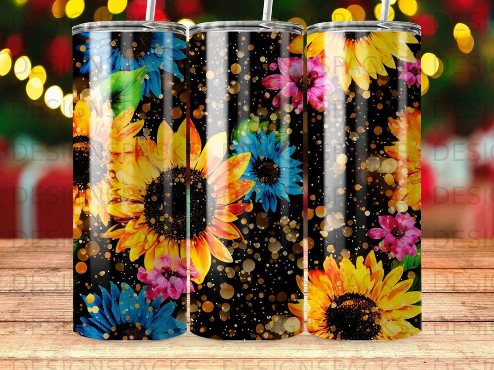 Three tumblers with sunflowers and floral designs on a dark background.