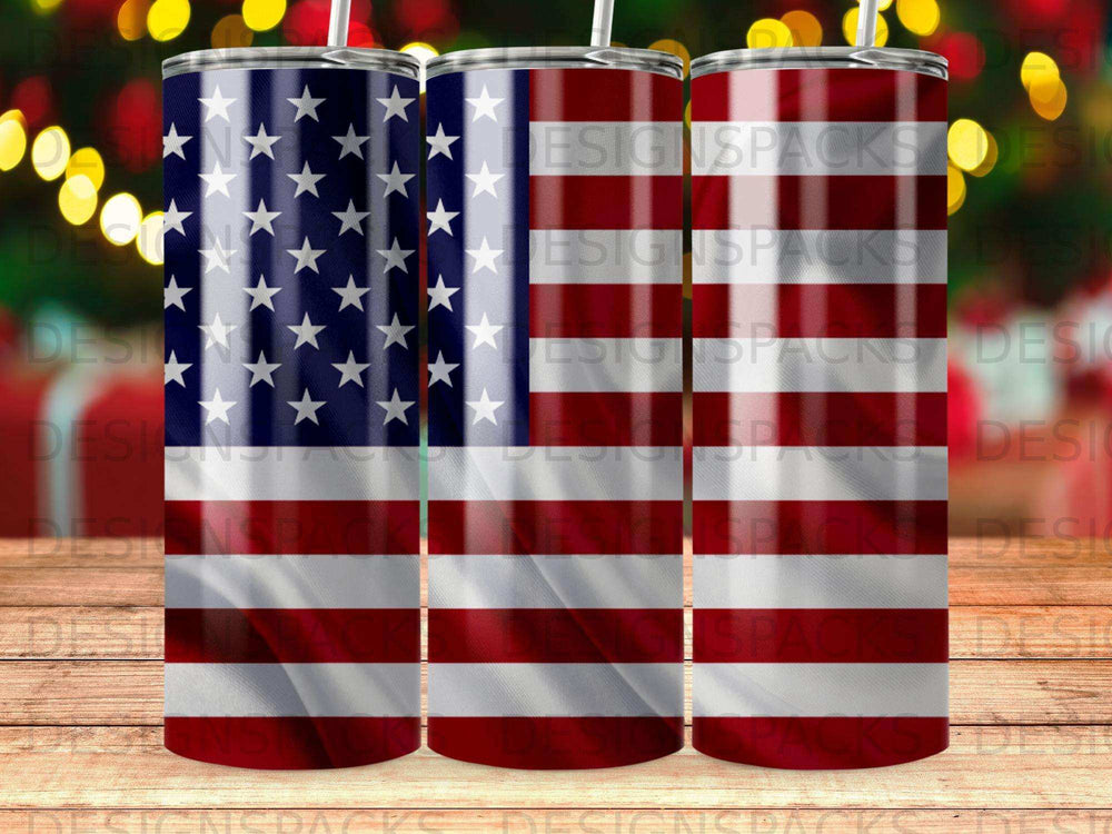 Three tumblers with American flag design, wood grain background, blurred bokeh lights.