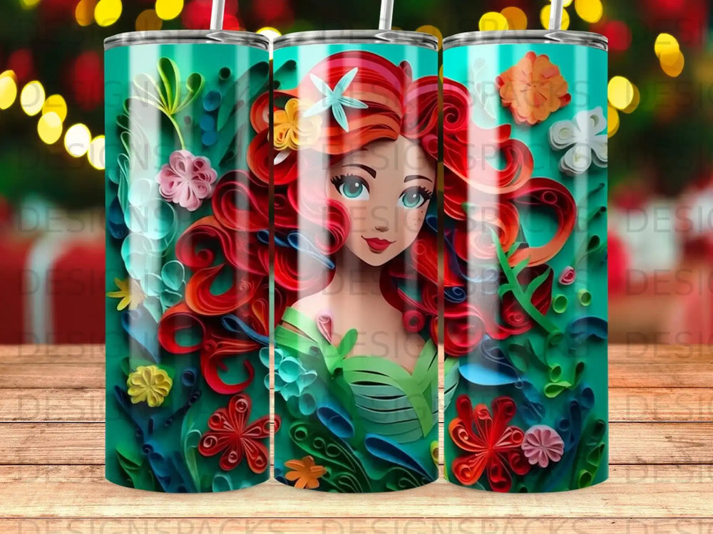 Red-haired mermaid with green dress on teal tumbler with floral underwater design.