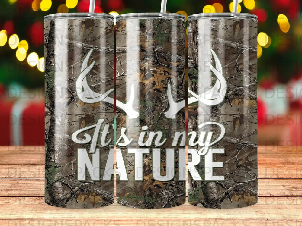 Camouflage tumbler with white deer antlers and "It's in my NATURE" text.