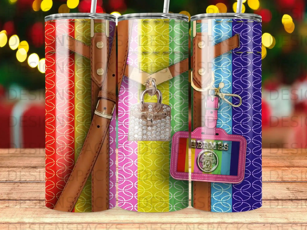 Three tumblers with colorful striped patterns and leather accents, one with a diamond charm.