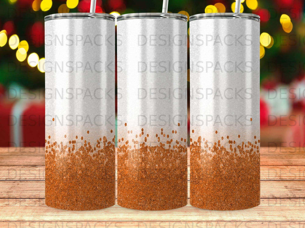 Three tumblers with a shimmering orange glitter bottom and a white top.