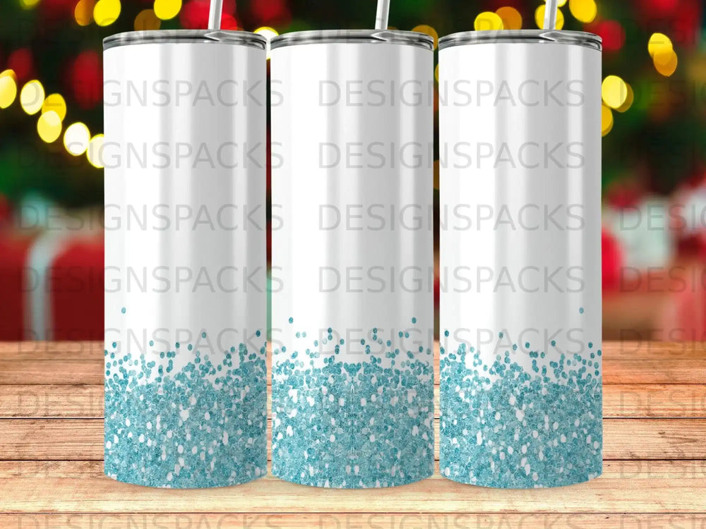 Three blank white tumblers with a light blue glitter bottom on a wooden surface.