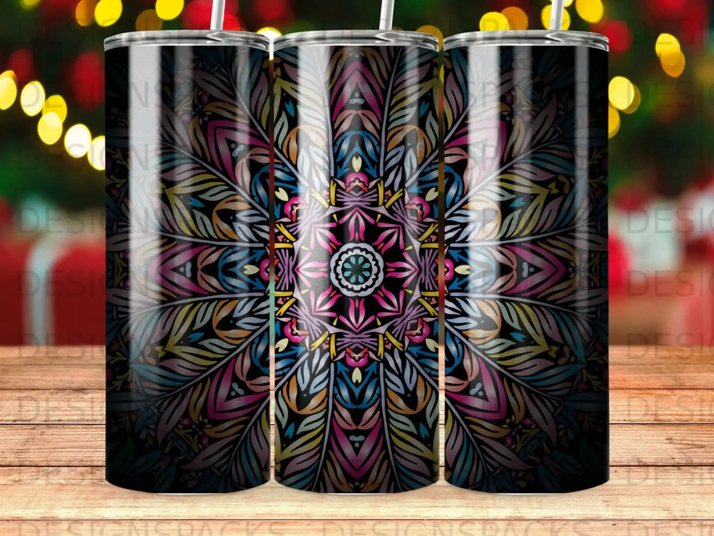 Black tumbler with colorful mandala pattern and decorative lights in background.