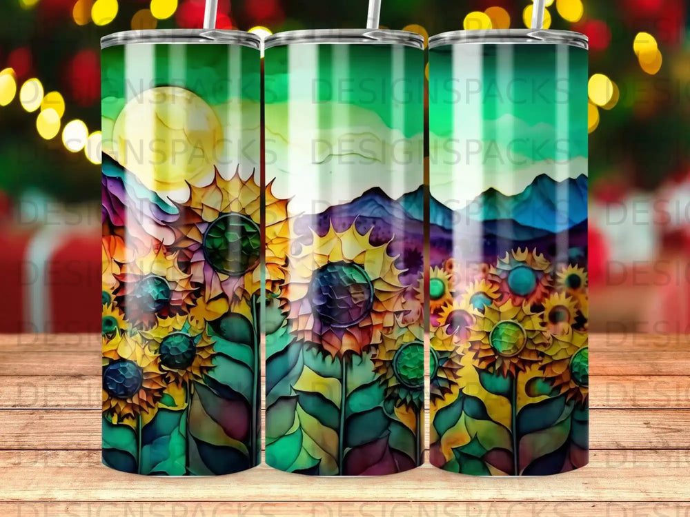 Three tumblers with a vibrant sunflower and mountain landscape design.
