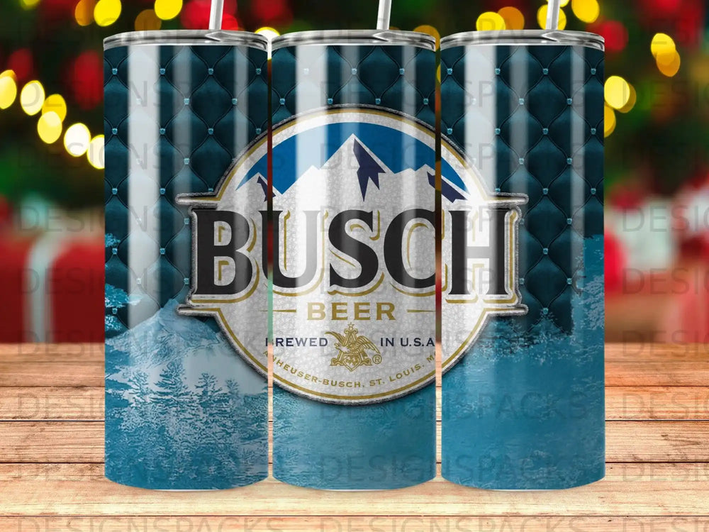 Busch Beer tumbler with mountains and frosted trees on a blue quilted background.