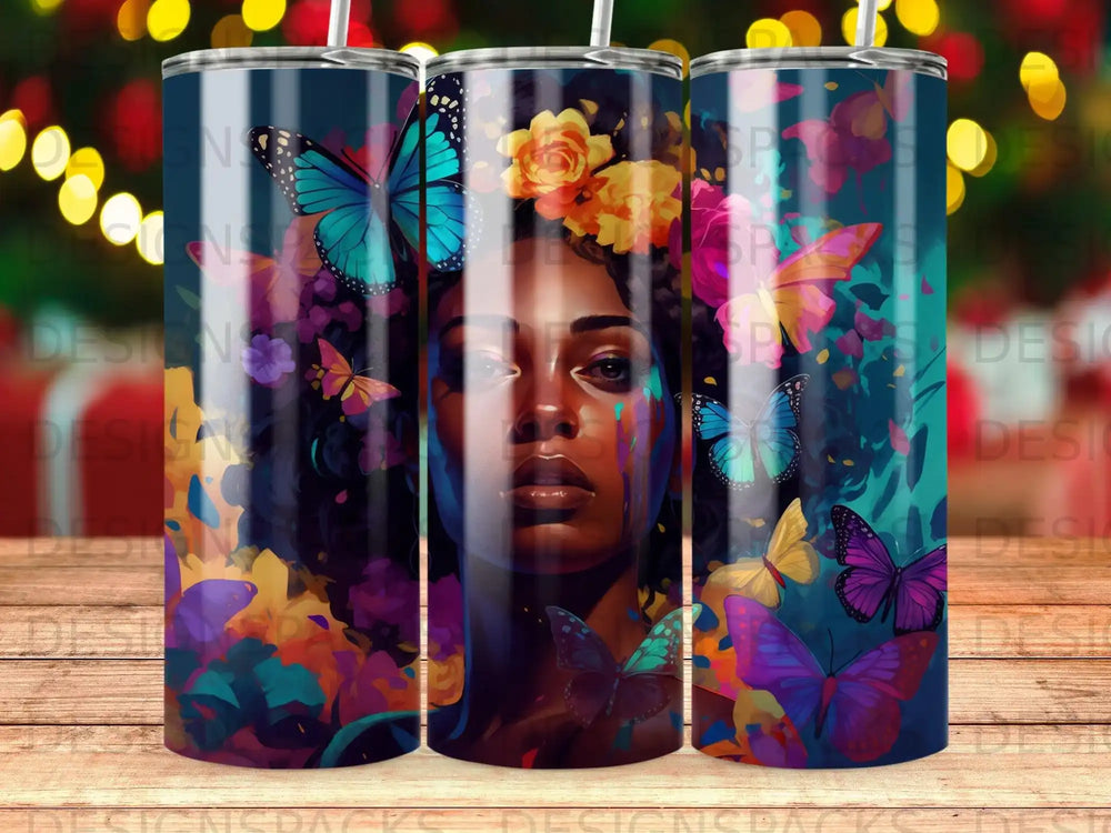 Tumbler with a woman's face adorned with colorful butterflies and flowers.