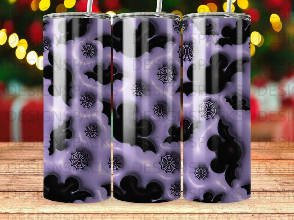 Purple tumbler with bats and spiderwebs pattern on wooden surface.