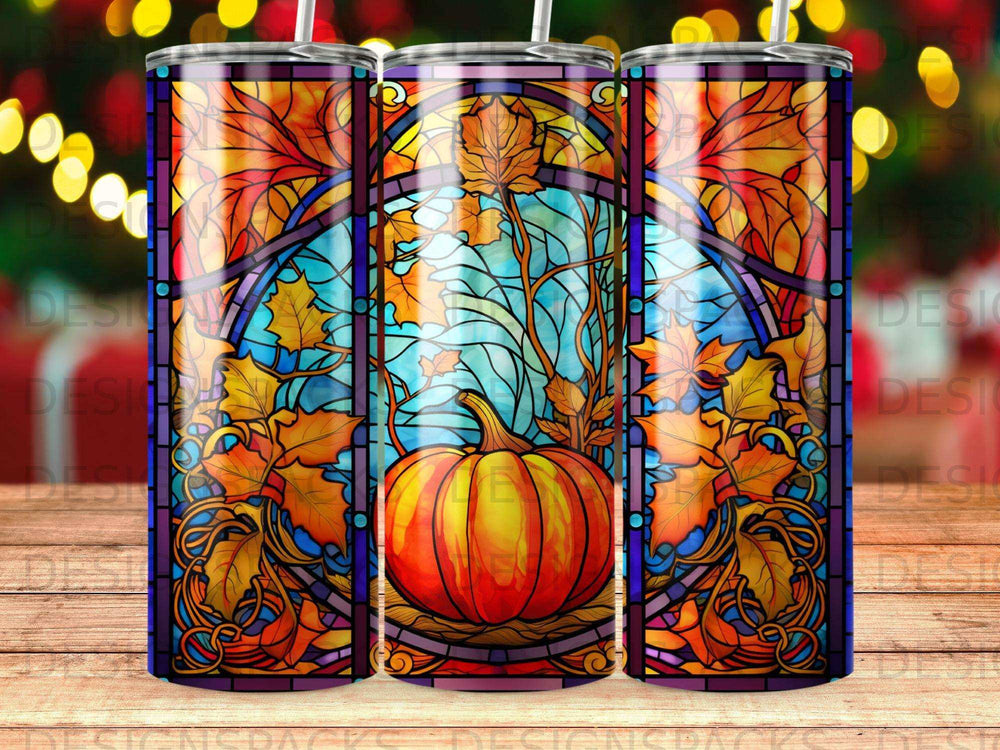 Stained glass tumbler featuring a pumpkin, autumn leaves, and a blue sky.