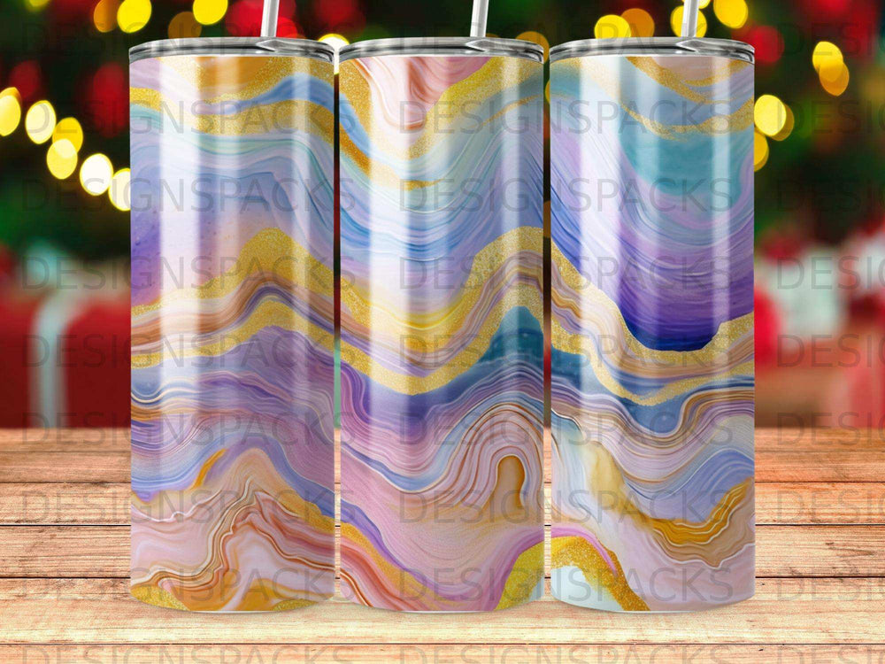 Three tumblers with marbled patterns and gold accents on a wooden background.