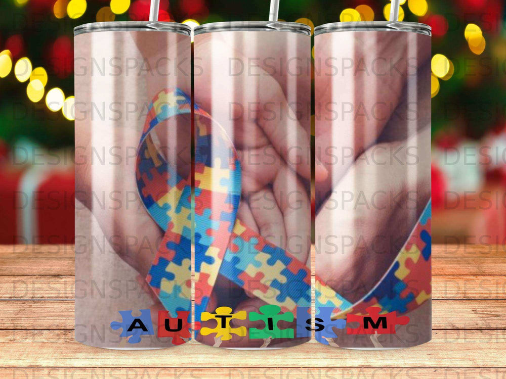 Tumbler with autism puzzle ribbon design and "Autism" text.