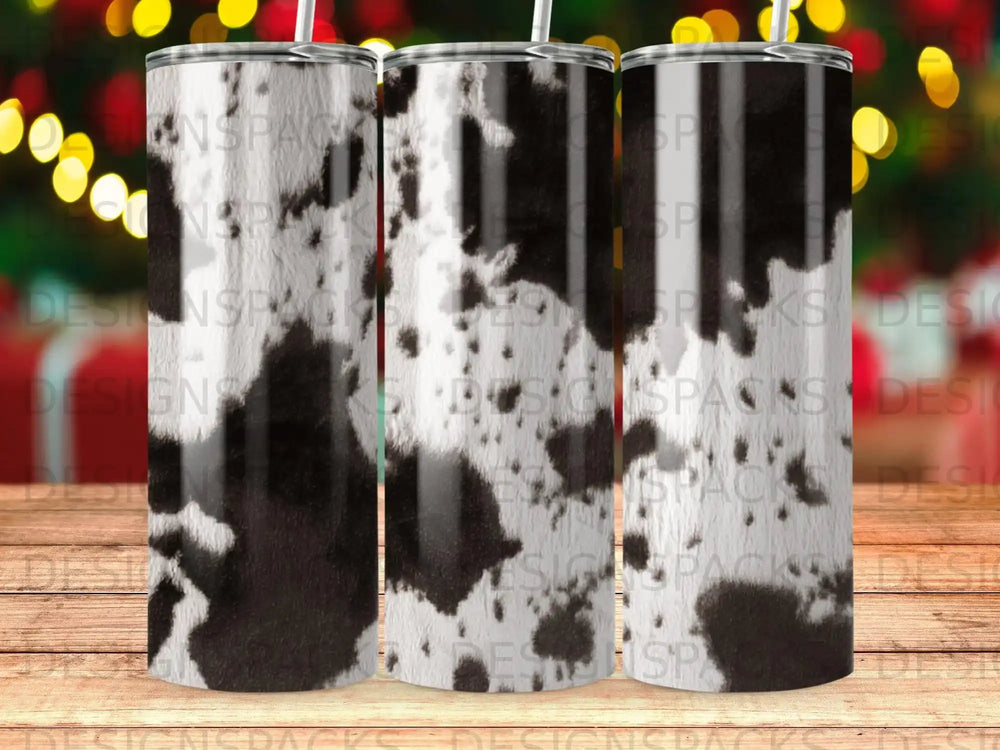 Tall tumbler with cowhide print design on wooden table.