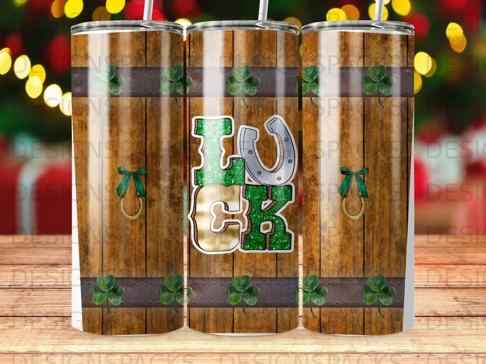 Tumbler with "Luck" in green glitter and a horseshoe charm on wood grain background.