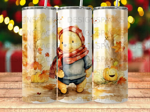 Winnie the Pooh wearing a scarf with autumn leaves and pumpkins.