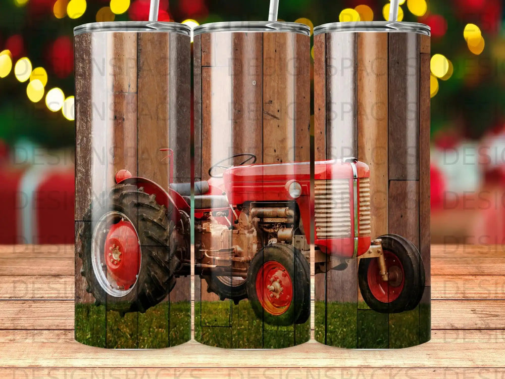 Vintage red tractor on wooden background with grass in foreground.
