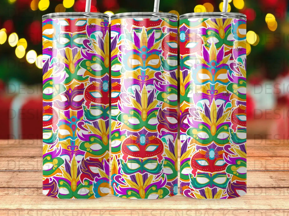 Three colorful Mardi Gras masks decorate a patterned tumbler with a blurred bokeh background.