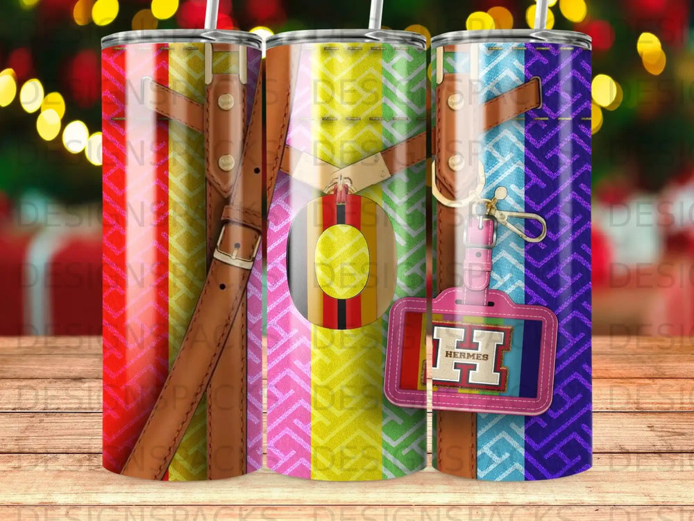 Three Hermes-branded tumblers with colorful geometric patterns and leather strap details.