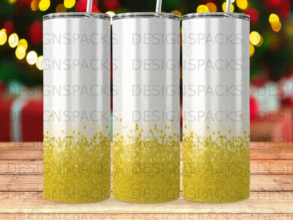 Three white tumblers with gold glitter gradient on a wooden surface.