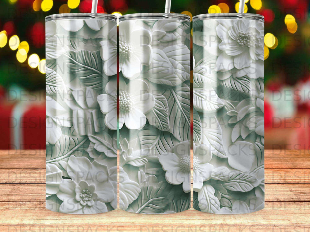 White floral pattern on three tumblers with bokeh background.