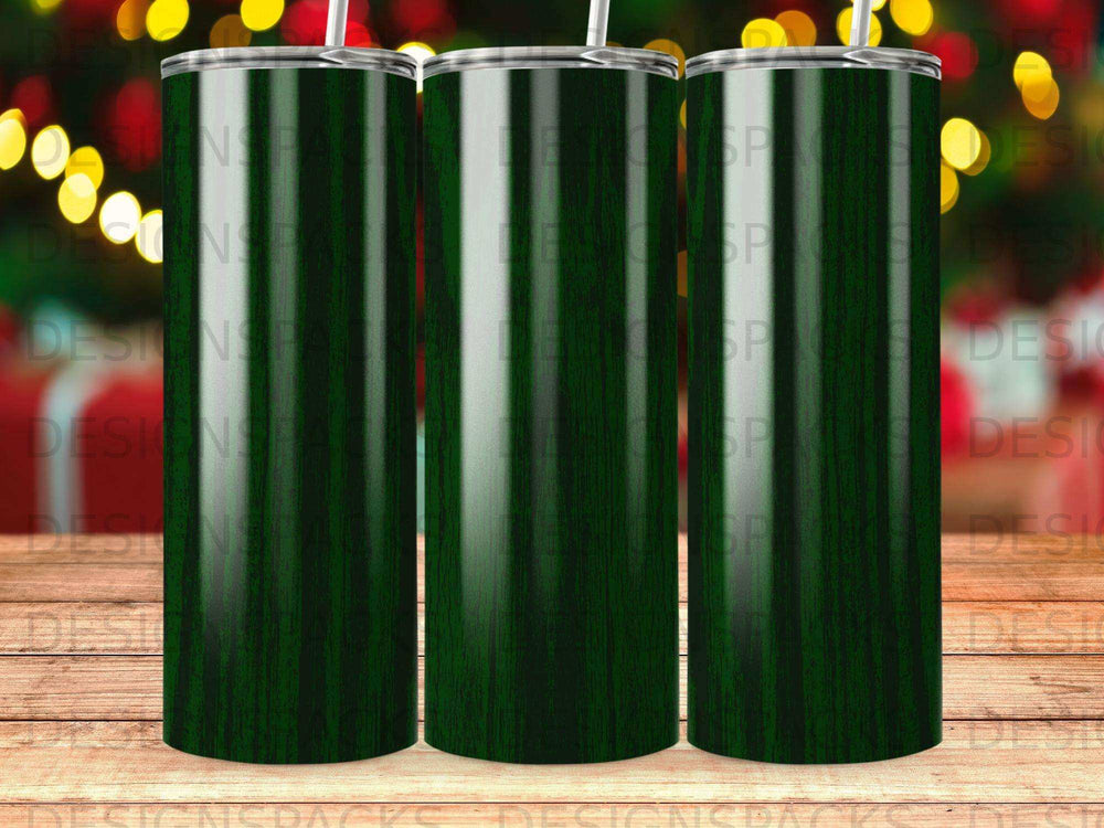 Green wood grain tumbler with straw, with a blurred Christmas tree background.