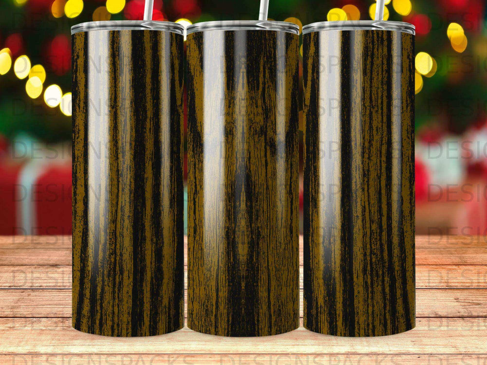 Three striped tumblers with straws against a bokeh background.