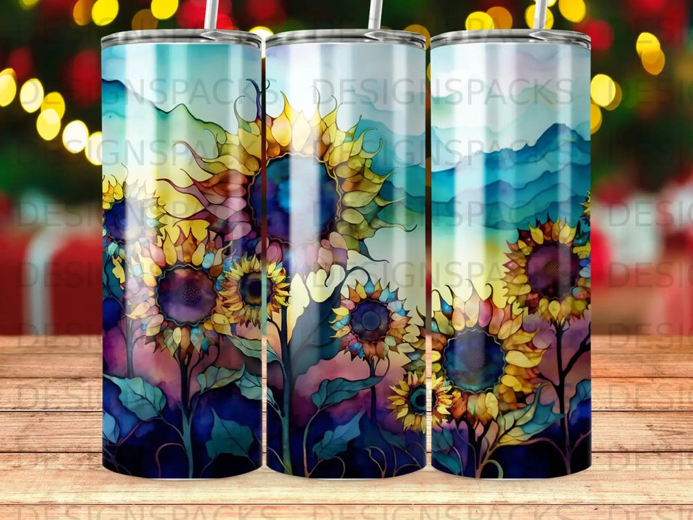 Three tumblers with a watercolor sunflower and mountain landscape design.