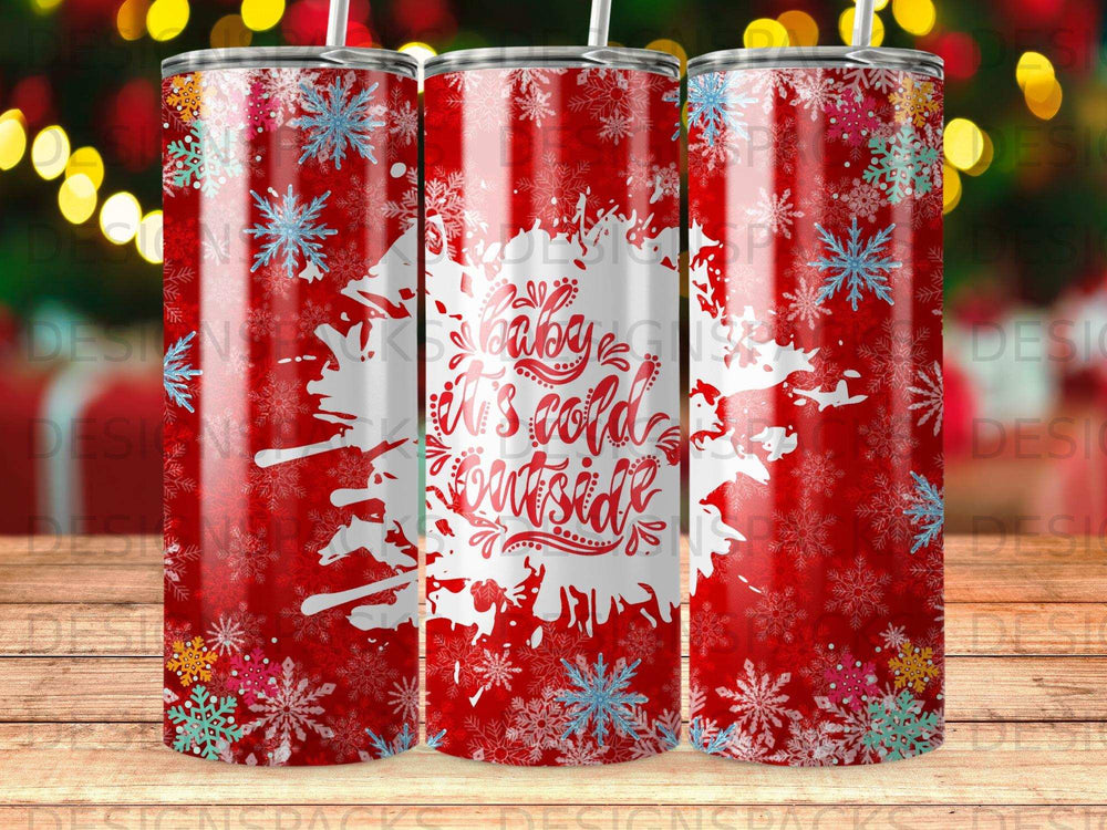 Red tumbler with "baby it's cold outside" in white, snowflakes, and festive lights.
