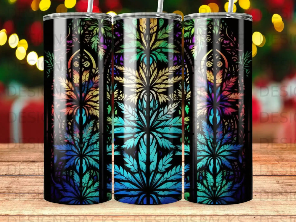 Three tumblers with a colorful cannabis leaf pattern on a wooden surface.