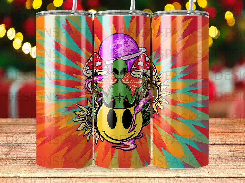 Alien and smiley face with mushrooms and sunburst pattern on a tumbler.