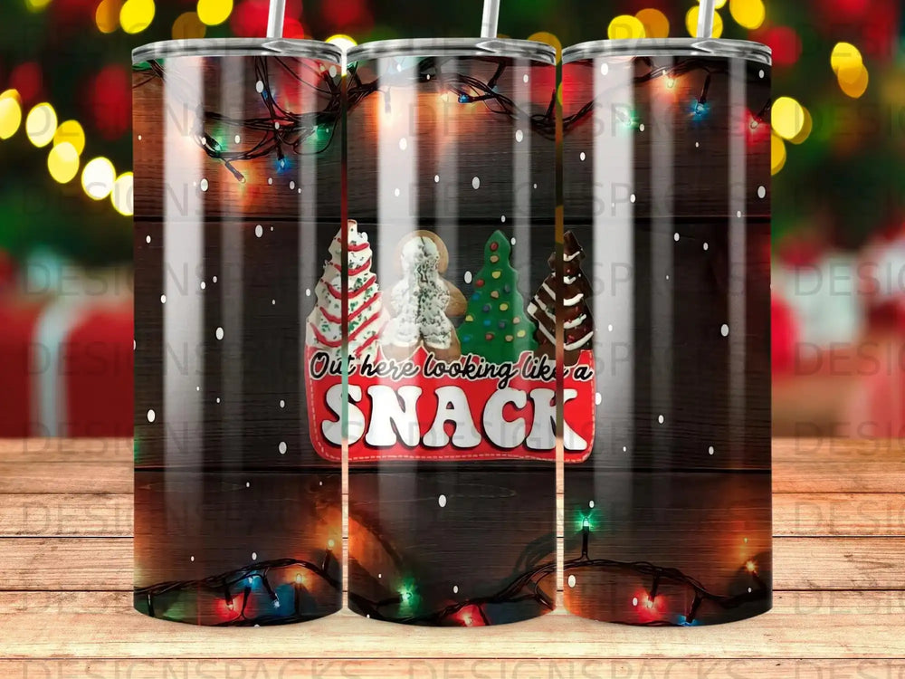 Tumbler with wood grain, Christmas lights, and decorated gingerbread cookies that say "Out here looking like a snack".