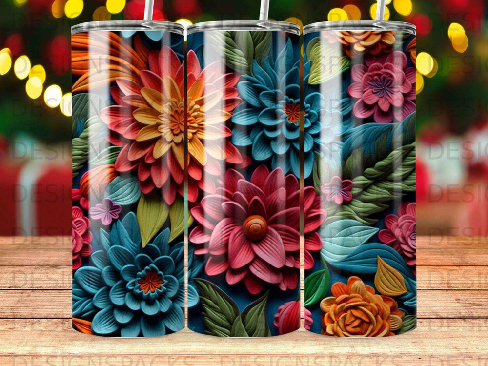 Three tumblers with colorful embossed floral designs and bokeh lights background.