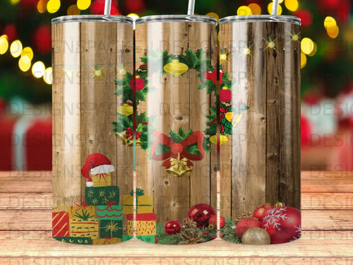 Holiday tumbler with Christmas wreath, gifts, and ornaments on rustic wood.
