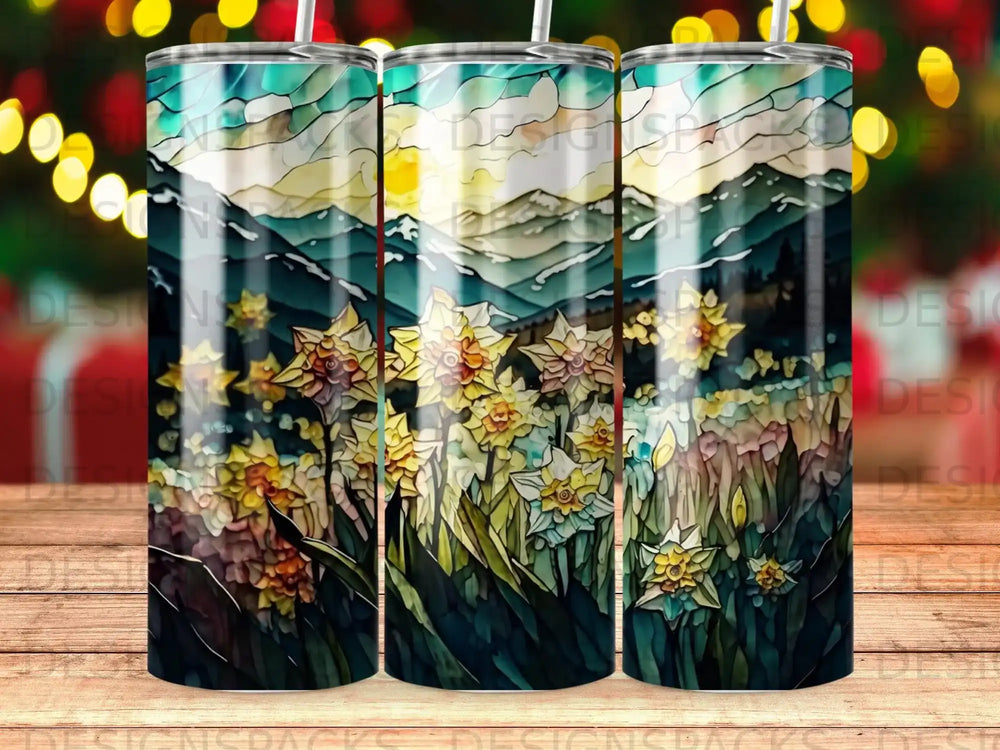 Daffodils and mountains under a colorful sky on a tumbler.