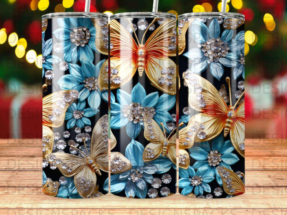 Three tumblers with gold butterflies and blue floral designs on black striped background.