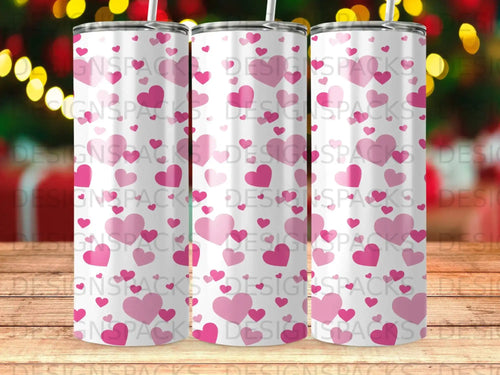 Three tall, skinny tumblers with a repeating pink heart pattern.