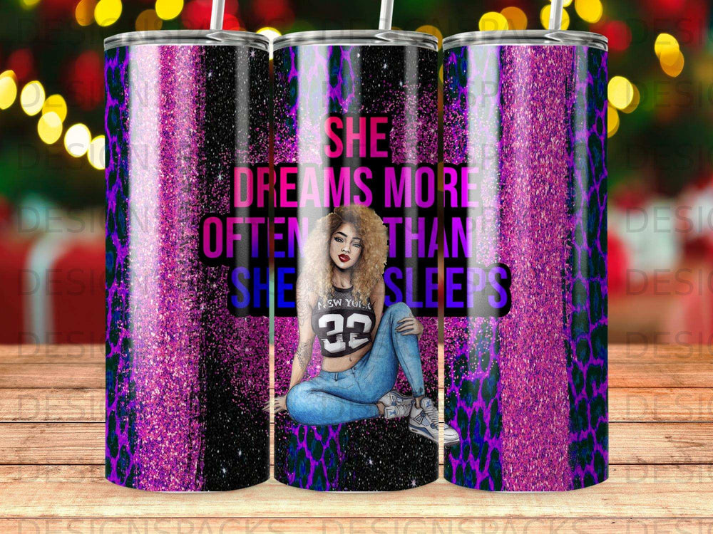 Tumbler with "She dreams more often than she sleeps" text and woman illustration.